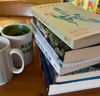 photo of several books and a mug on a table