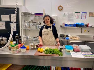 Fadia in a kitchen preparing vegetables.